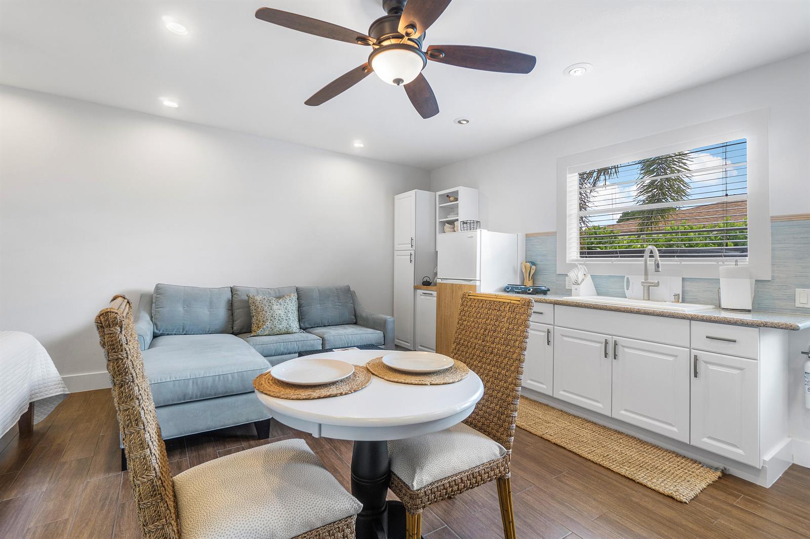 A studio apartment features a kitchenette, a dining set, and a sofa on wood floors — 43 W Plumosa Lane, FL 33467, FL