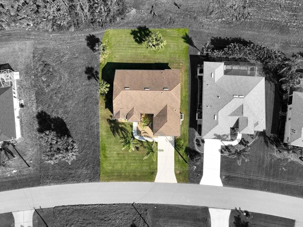 An aerial view shows a house with a brown roof centered on a grassy lot — 127 WHITE MARSH LANE, ROTONDA WEST, FL