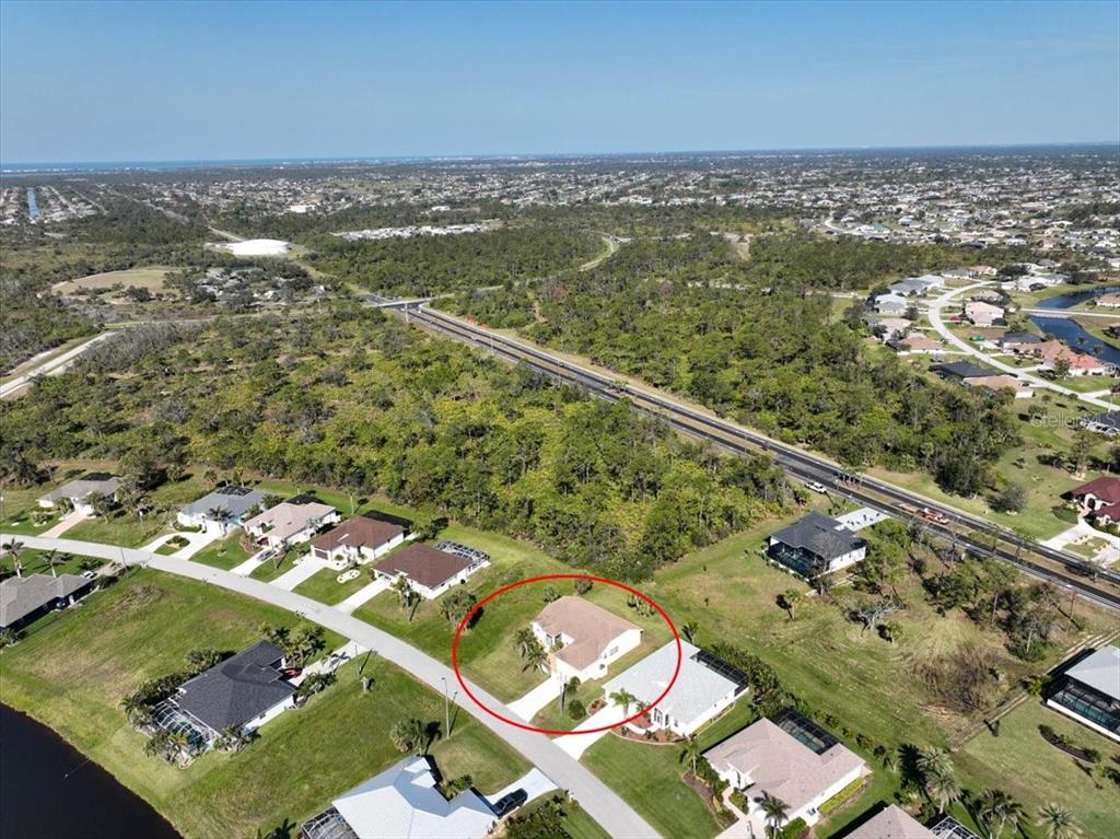 An aerial view shows a single-story house circled in red within a suburban neighborhood — 127 WHITE MARSH LANE, ROTONDA WEST, FL