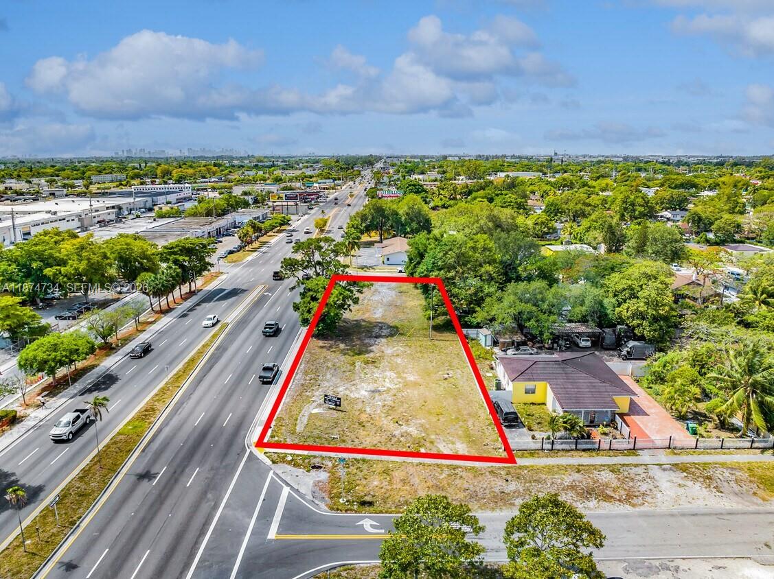 An aerial view shows a vacant rectangular lot outlined in red next to a road — NW 27th, Opa-Locka FL 33054, OPA-LOCKA, FL