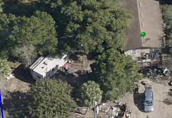 An aerial view shows a house, a parked RV, and a car on a wooded lot — 33702 VERDA AVENUE, LEESBURG, FL