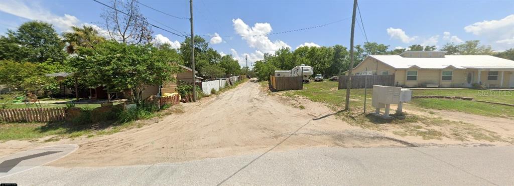 A dirt road leads between two residential properties with fences and a cluster of mailboxes — 33702 VERDA AVENUE, LEESBURG, FL