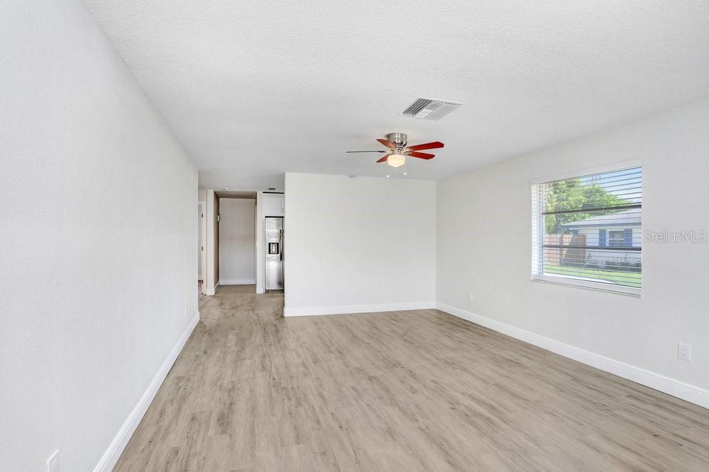 An empty room with light wood-look flooring, a ceiling fan, and a window — 3166 DOWNING STREET, CLEARWATER, FL