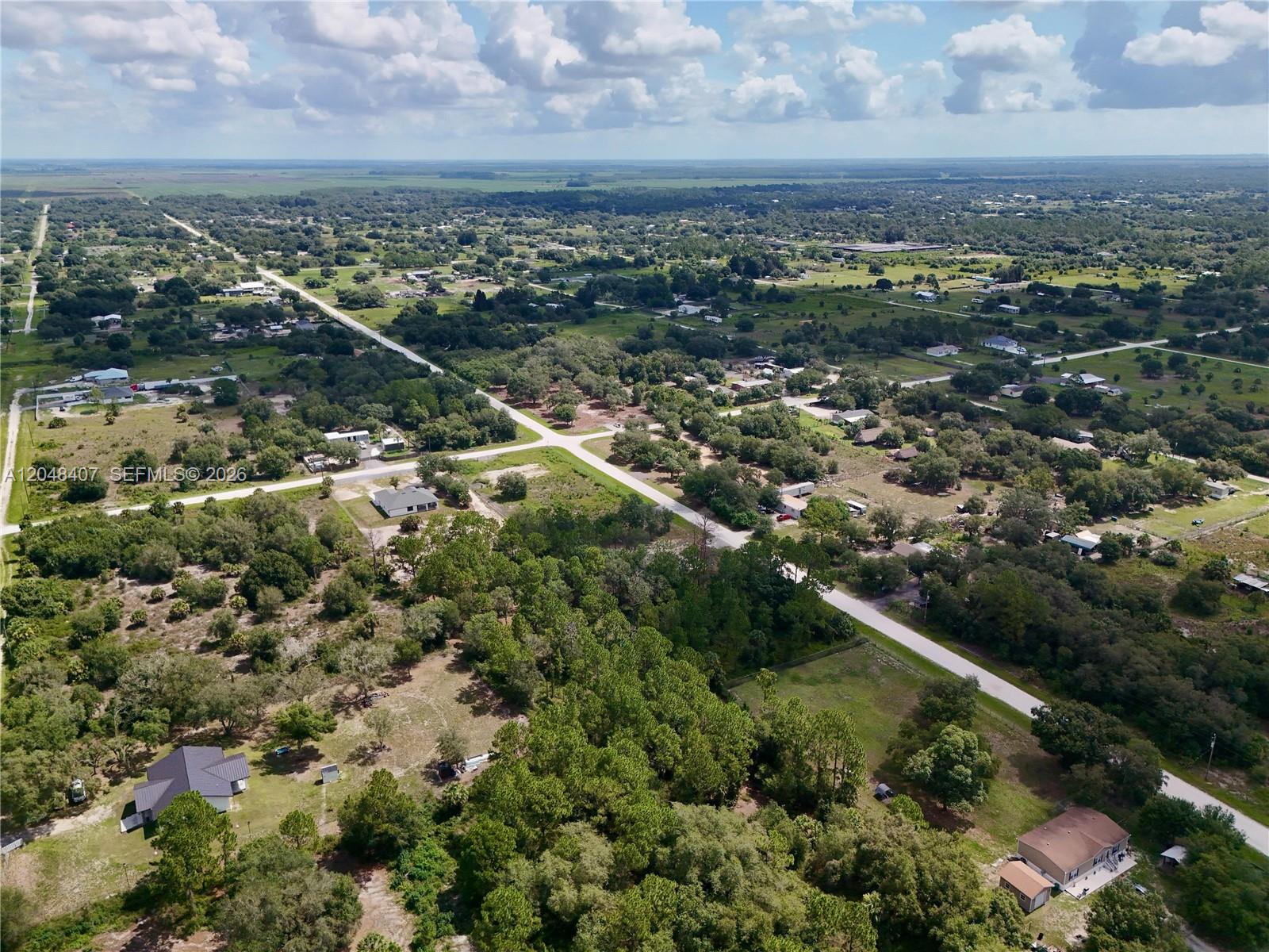 An aerial view shows a rural landscape with scattered houses, wooded areas, and intersecting roads — 270 N DATIL ST, Clewiston FL 33440, CLEWISTON, FL