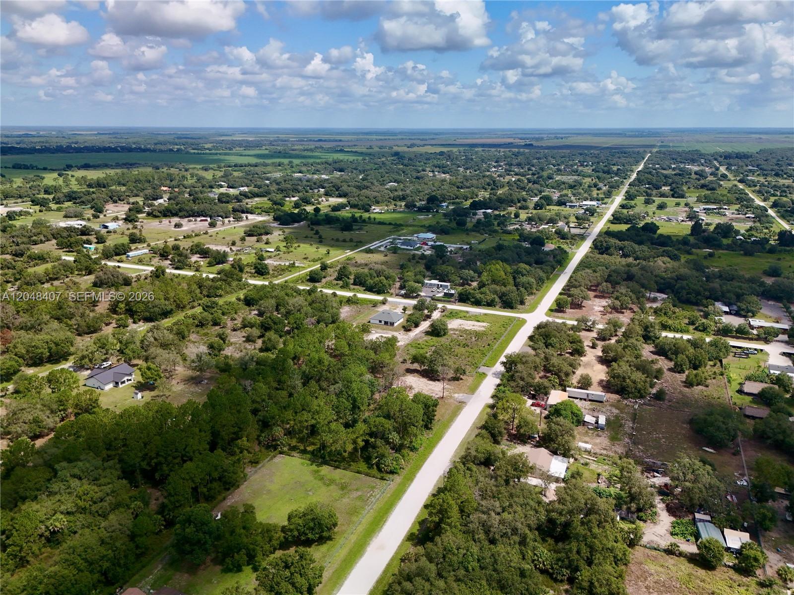 An aerial view shows a rural landscape with scattered houses, dirt roads, and wooded areas — 270 N DATIL ST, Clewiston FL 33440, CLEWISTON, FL
