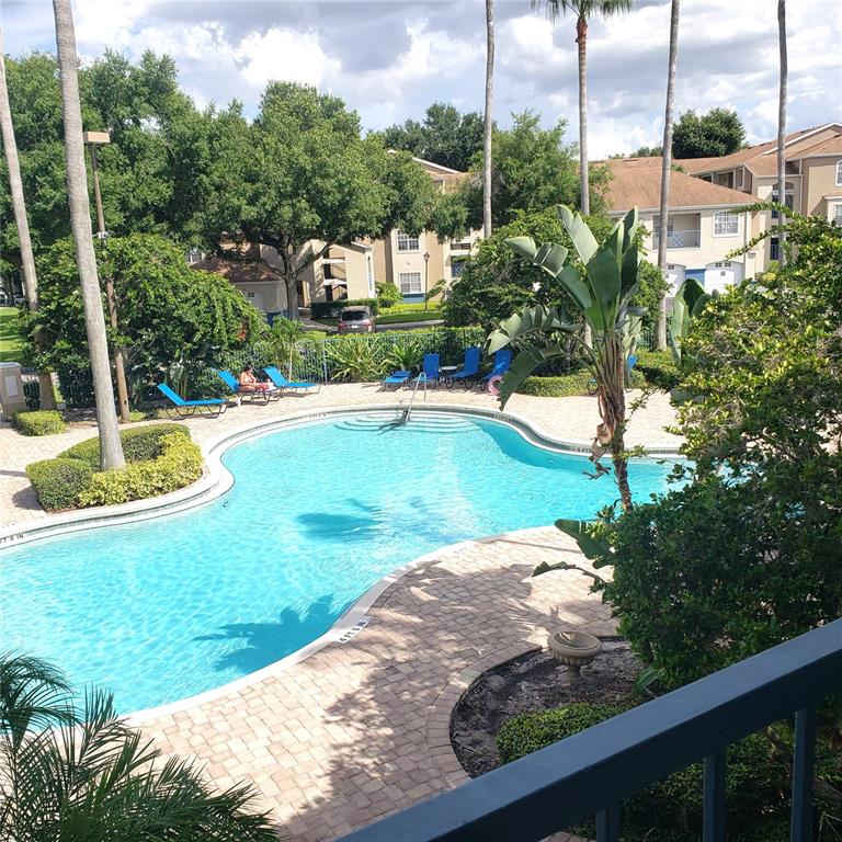 A swimming pool with lounge chairs is surrounded by a paved deck and apartment buildings — 7300 WESTPOINTE BOULEVARD UNIT 732, ORLANDO, FL