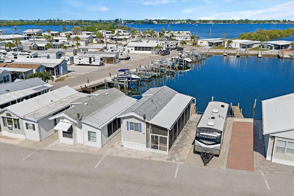 An aerial view shows several mobile homes situated along a canal with boat docks — 108 BAHIA DRIVE, PALMETTO, FL
