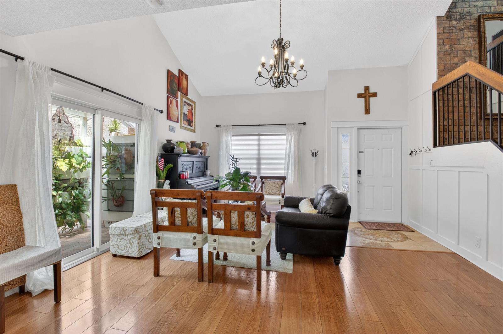 A living room features hardwood floors, a vaulted ceiling, a piano, and a front entryway — 22859 N Sandalfoot Boulevard, Boca Raton FL 33428, BOCA RATON, FL