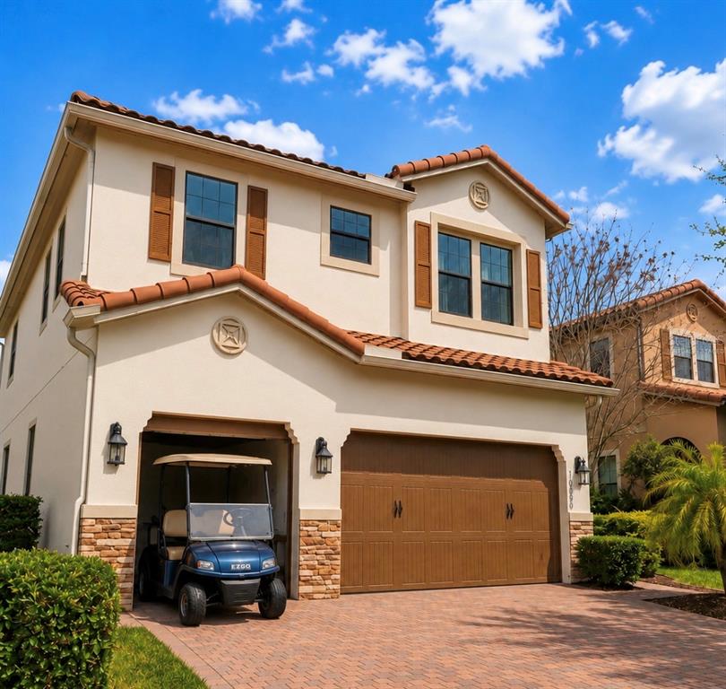 A two-story stucco house with a tile roof, a two-car garage, and a parked golf cart — 10359 HENBURY STREET, ORLANDO, FL