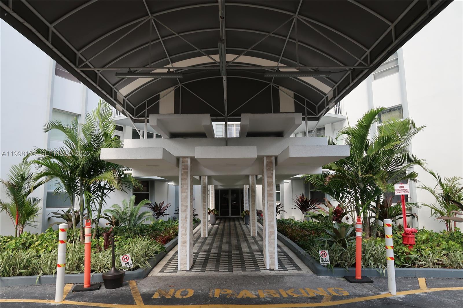 The exterior entrance features a covered walkway with a metal canopy and stone pillars — 1913 S Ocean Dr # 300, Hallandale Beach FL 33009, HALLANDALE BEACH, FL