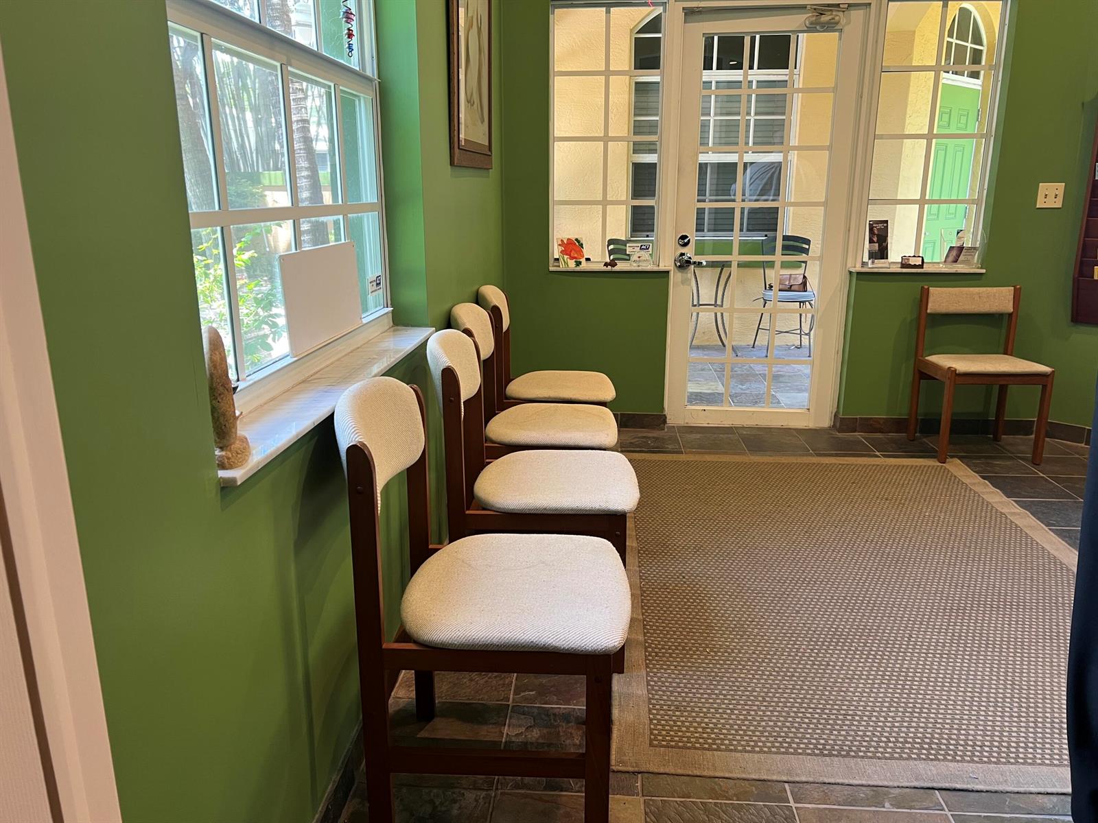 A waiting room with green walls, a row of four chairs, and a glass-paned door — 720 NE 3rd, Fort Lauderdale FL 33304, FORT LAUDERDALE, FL