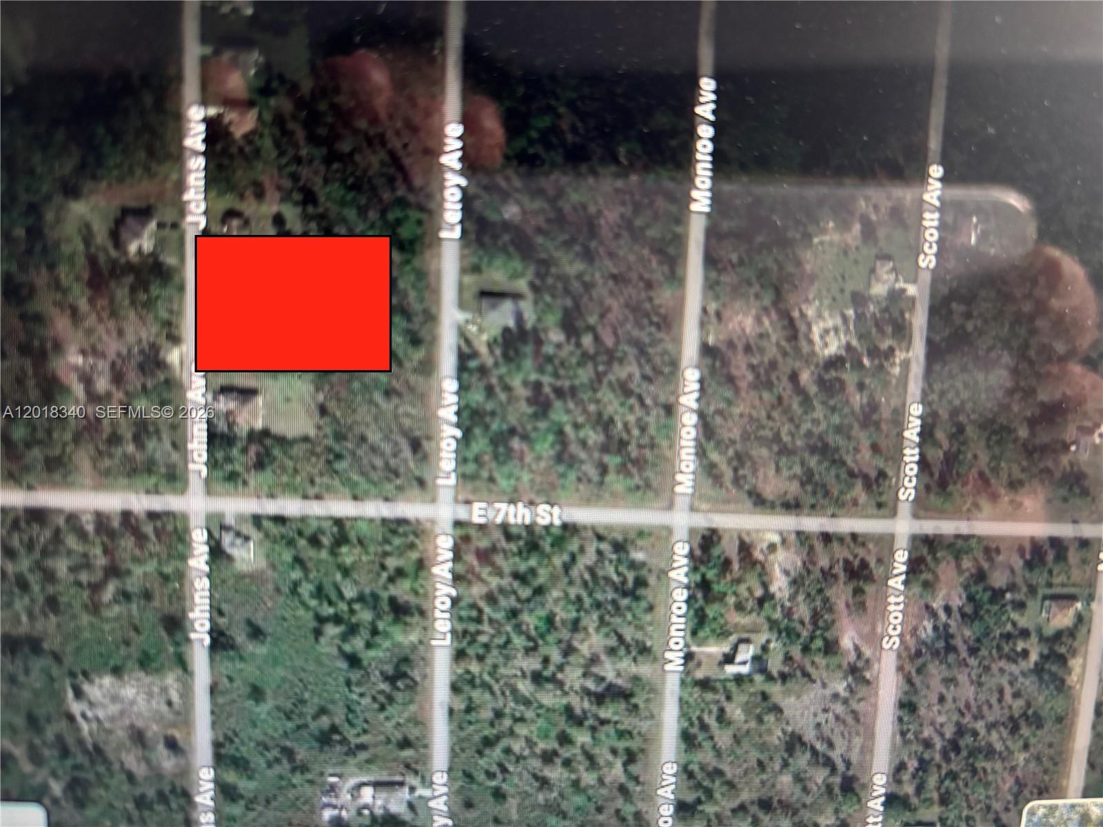 This is an aerial map view showing a red rectangle over a wooded lot — 706 JOHNS AVE, Lehigh Acres FL 33972, LEHIGH ACRES, FL