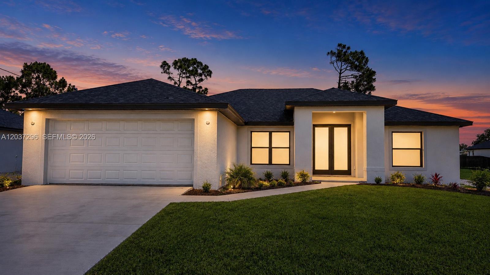 A single-story house with a white stucco exterior, a two-car garage, and a front entryway — 4200 14th St SW, Lehigh Acres FL 33976, LEHIGH ACRES, FL