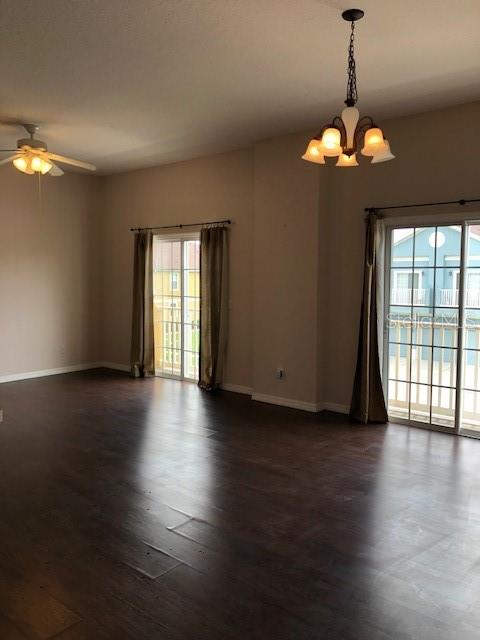 A living room with dark wood flooring, a ceiling fan, a chandelier, and sliding glass doors — 10923 DERRINGER DRIVE, ORLANDO, FL