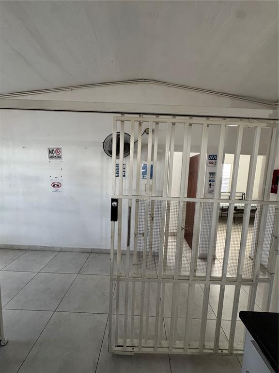 A tiled room features a white metal security gate and a wall-mounted fan — N618 CALLE JULIO ANDINO, SAN JUAN, PR