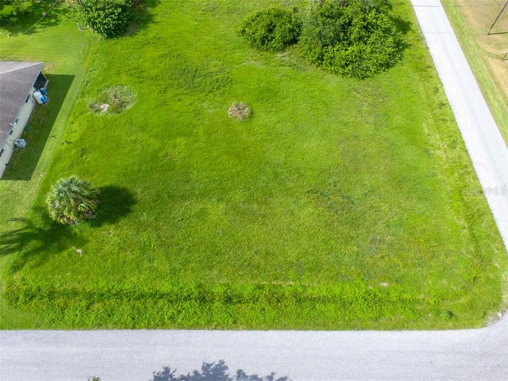 An elevated view of a vacant, grassy rectangular lot bordered by two paved roads — 12000 TAMIAMI LOTS 15 & 16 TRAIL S, NORTH PORT, FL