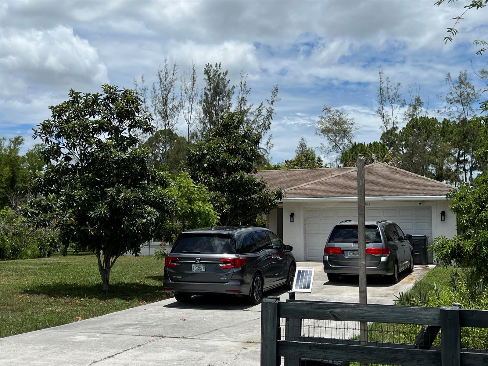 A single-story house with a two-car garage and two minivans parked in the driveway — 12403 N 87th St Street N, FL 33412, FL