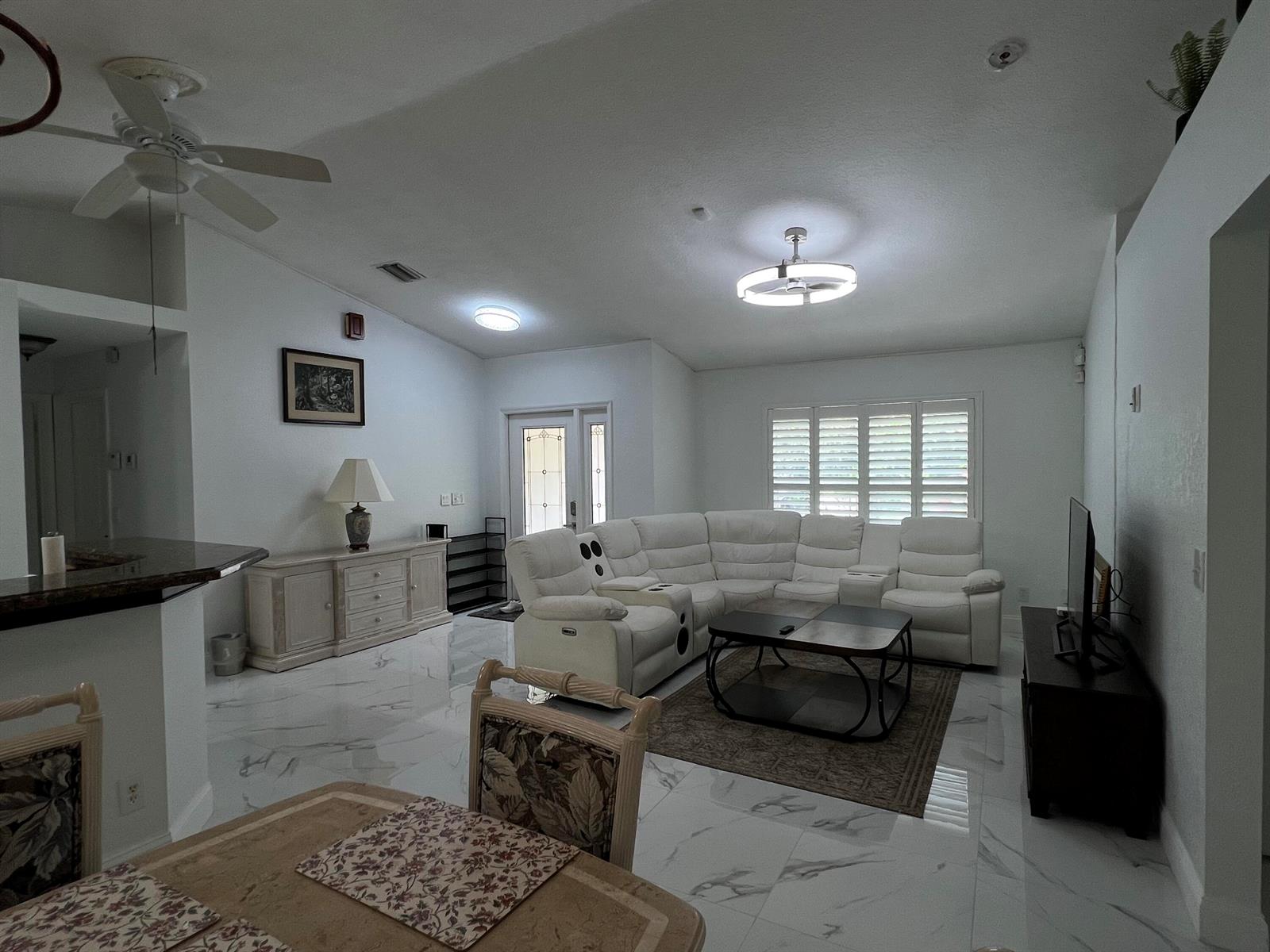 A living room features white marble floors, a large sectional sofa, and a ceiling fan — 12403 N 87th St Street N, FL 33412, FL