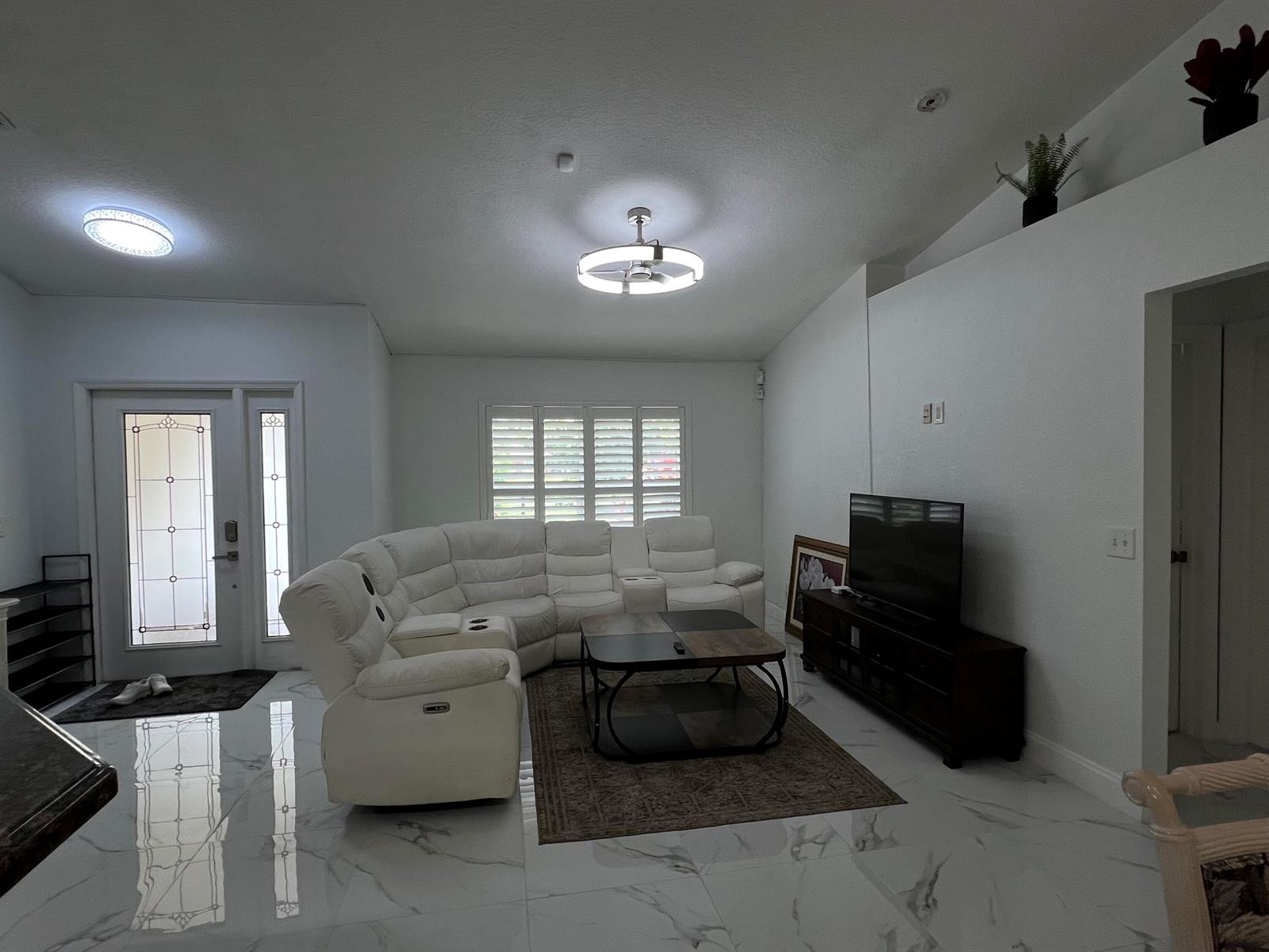 A living room features white tile flooring, a white sectional sofa, and a television console — 12403 N 87th St Street N, FL 33412, FL