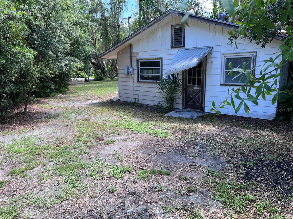 A small, weathered white house with a metal awning over the front door — 0 TRINIDAD STREET, SARASOTA, FL