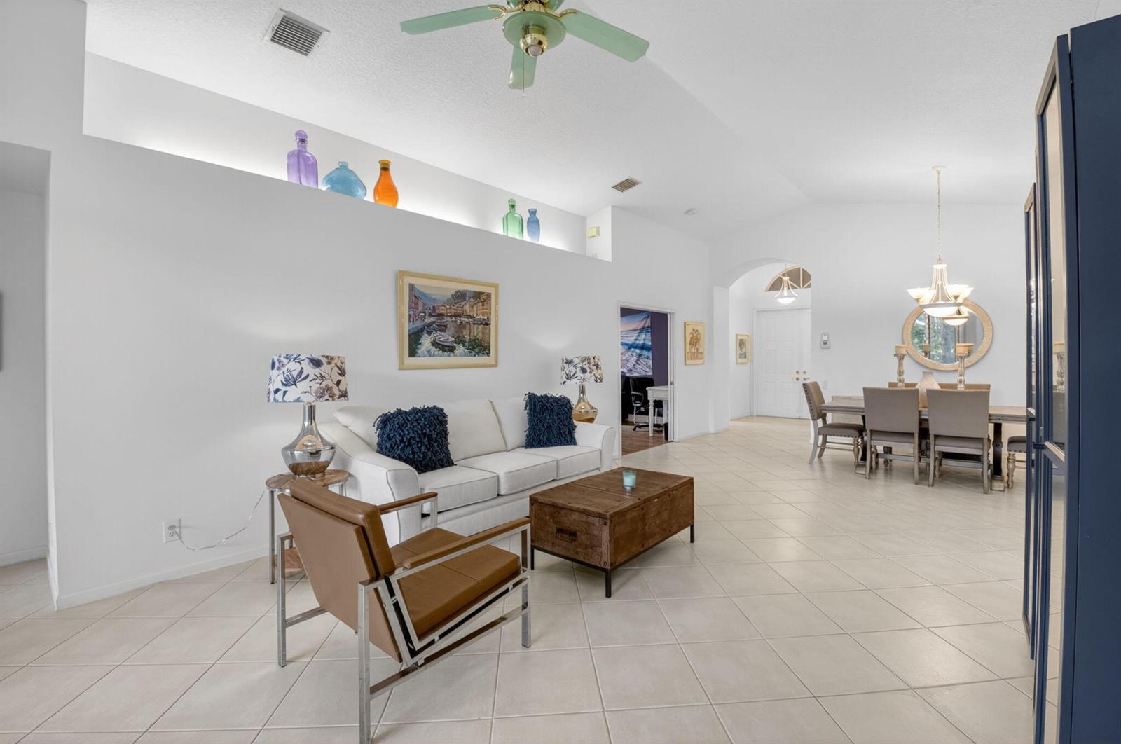 A living room with white walls, tile floors, a white sofa, and a dining area — 5304 Wycombe Avenue, Boynton Beach FL 33437, BOYNTON BEACH, FL