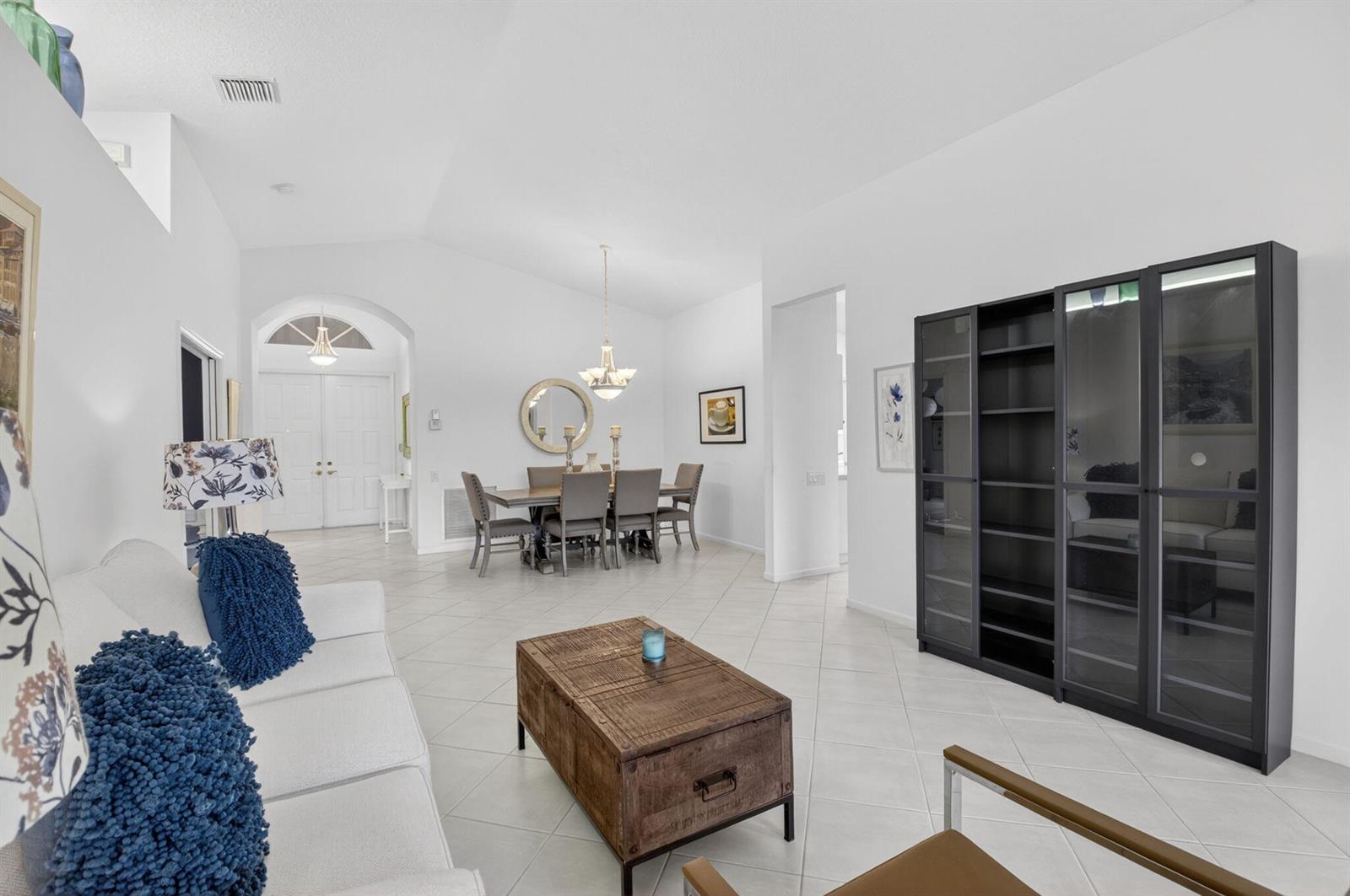 A bright living and dining area features white walls, tile flooring, and a dark cabinet — 5304 Wycombe Avenue, Boynton Beach FL 33437, BOYNTON BEACH, FL