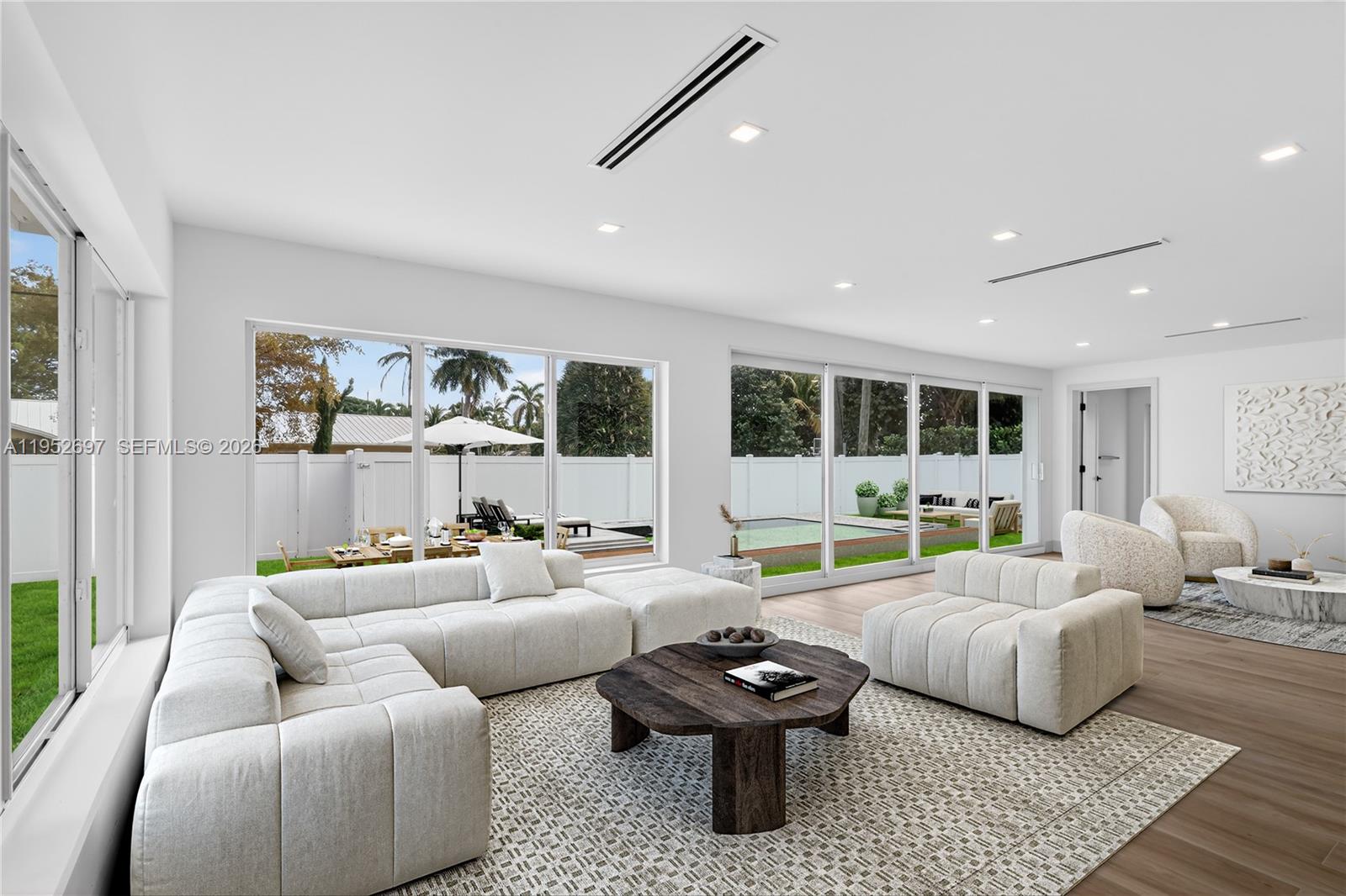 A modern living room features white walls, wood-look tile flooring, and a glass wine cellar — 1917 N Swinton Ave, Delray Beach FL 33444, DELRAY BEACH, FL