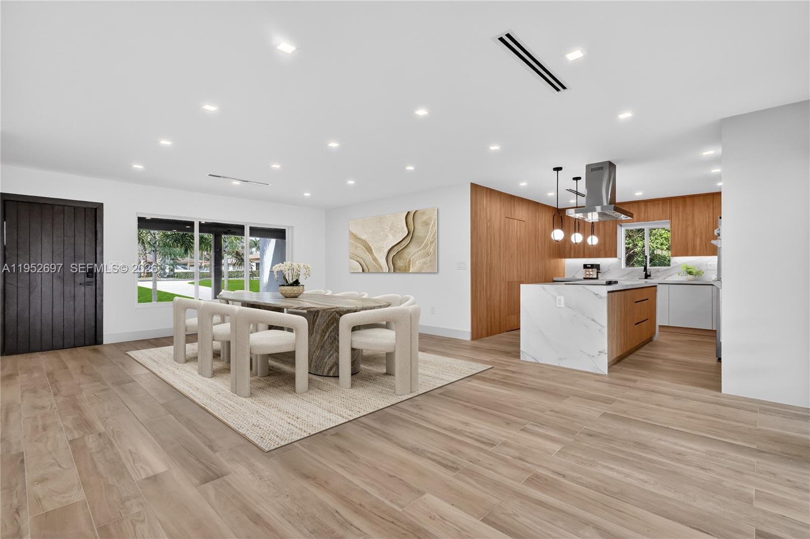 A white single-story house with a paved driveway and mature trees in the front yard — 1917 N Swinton Ave, Delray Beach FL 33444, DELRAY BEACH, FL