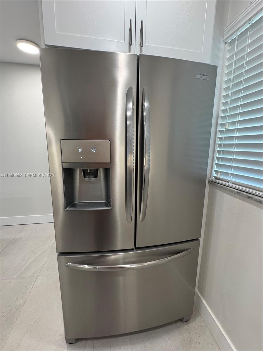 A stainless steel French door refrigerator is positioned in a kitchen with white cabinetry — 7810 Camino Real # 104, Miami FL 33143, MIAMI, FL