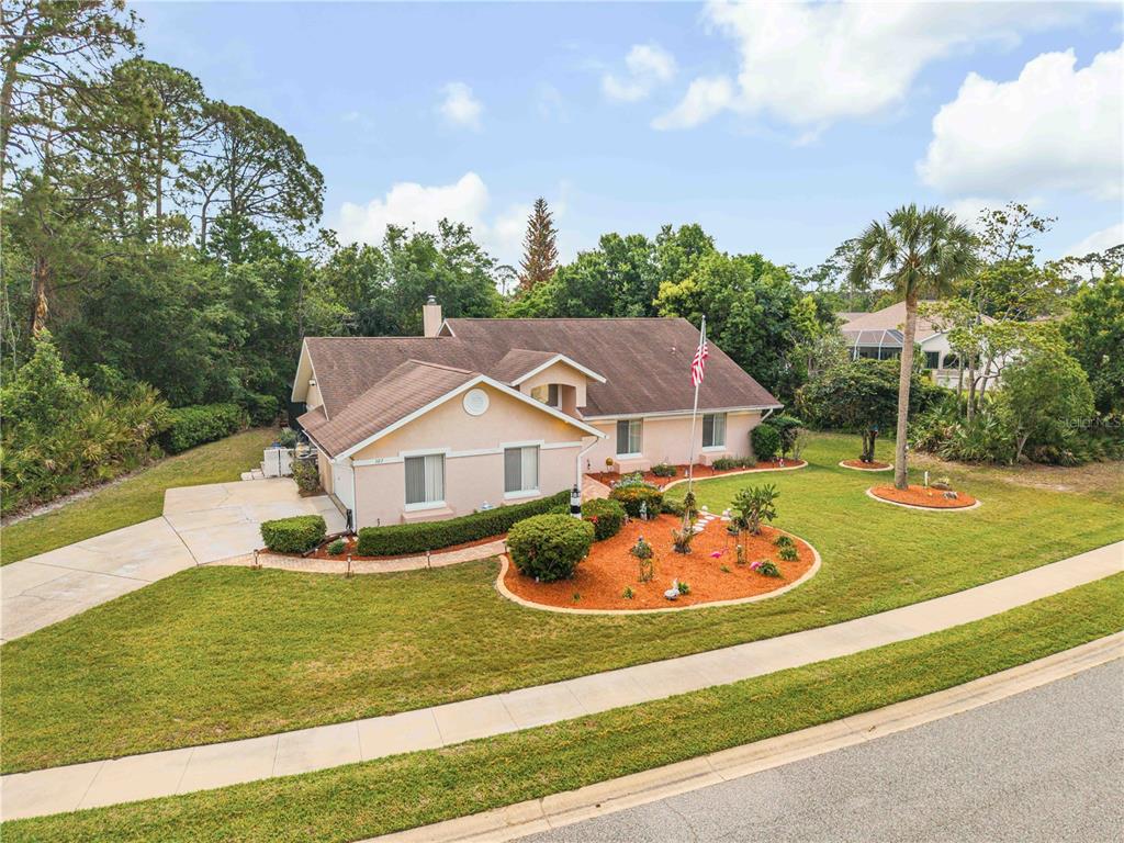 An aerial view of a single-story house with a tan exterior and a brown roof — 107 MUIRFIELD DRIVE, DAYTONA BEACH, FL