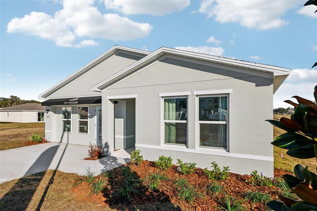 A single-story house with a light-colored stucco exterior, a concrete driveway, and a covered entryway — 6576 GURLEY STREET, INVERNESS, FL