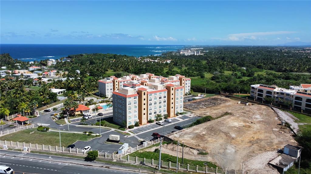 An aerial view shows a multi-story apartment complex next to a large, undeveloped dirt lot — PR 6690, VEGA ALTA, PR
