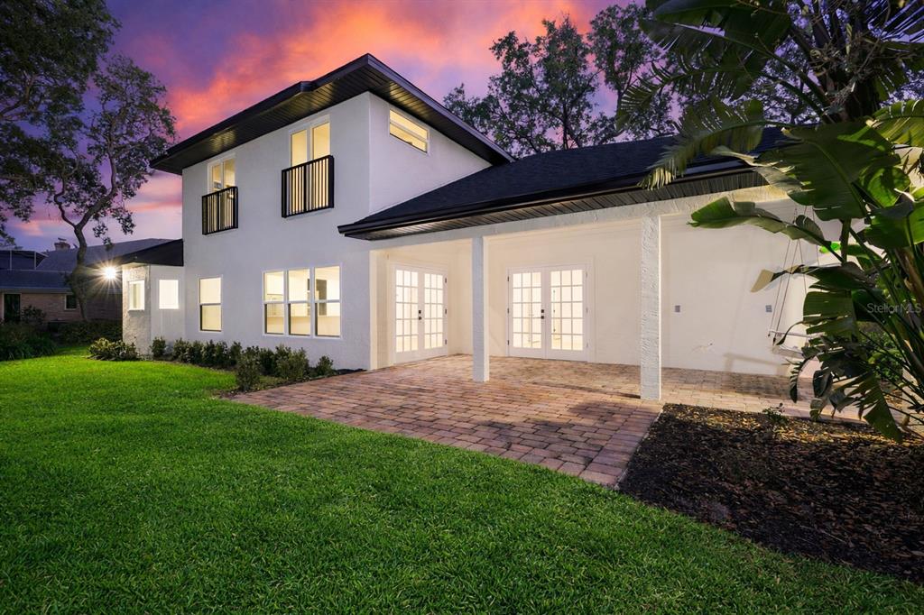 The exterior of a two-story white house features a paved patio and a grassy yard — 3311 OAK VISTA DRIVE, PORT ORANGE, FL