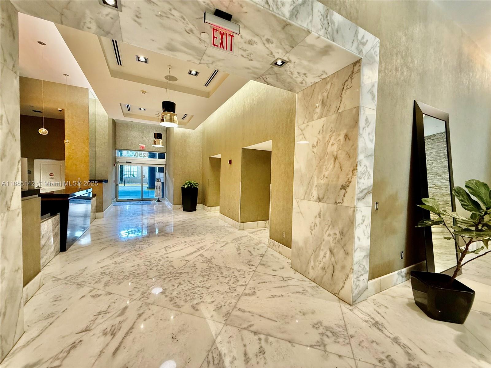 A modern lobby features marble floors, textured walls, recessed lighting, and a full-length mirror — 1250 S Miami # 1603, Miami FL 33130, MIAMI, FL