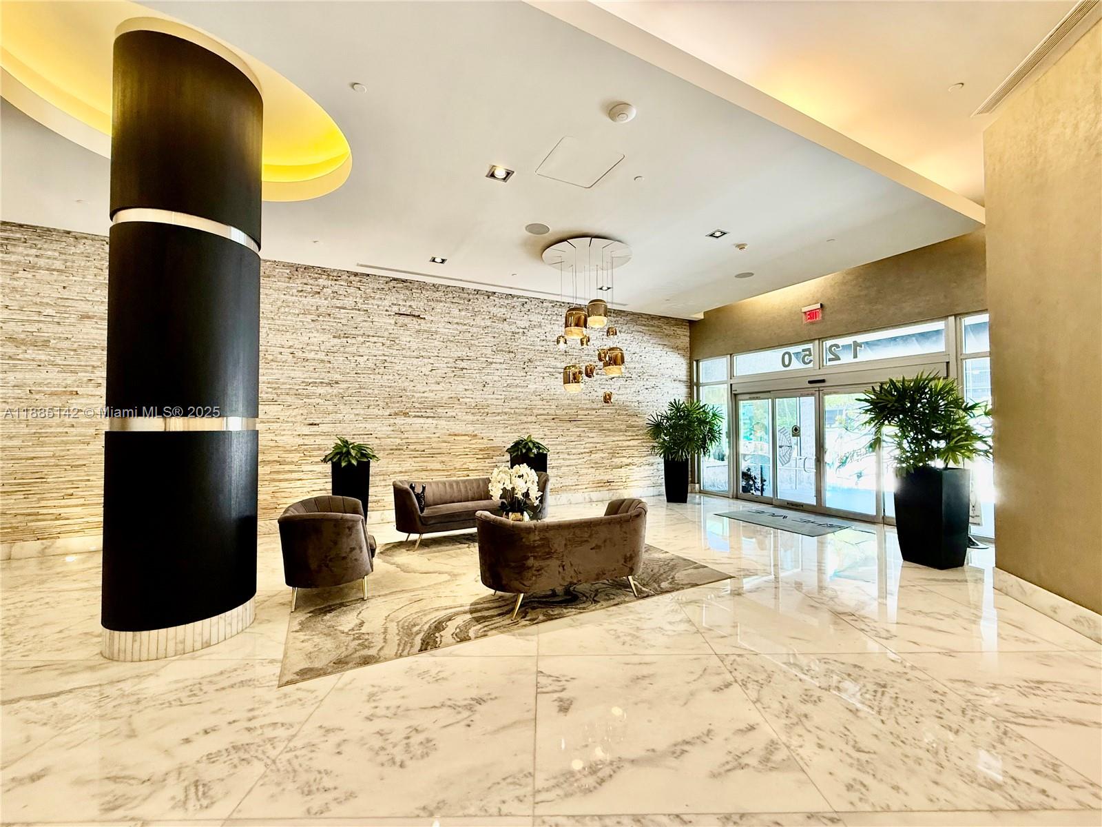 A modern lobby features a stone accent wall, marble flooring, and a dark cylindrical column — 1250 S Miami # 1603, Miami FL 33130, MIAMI, FL