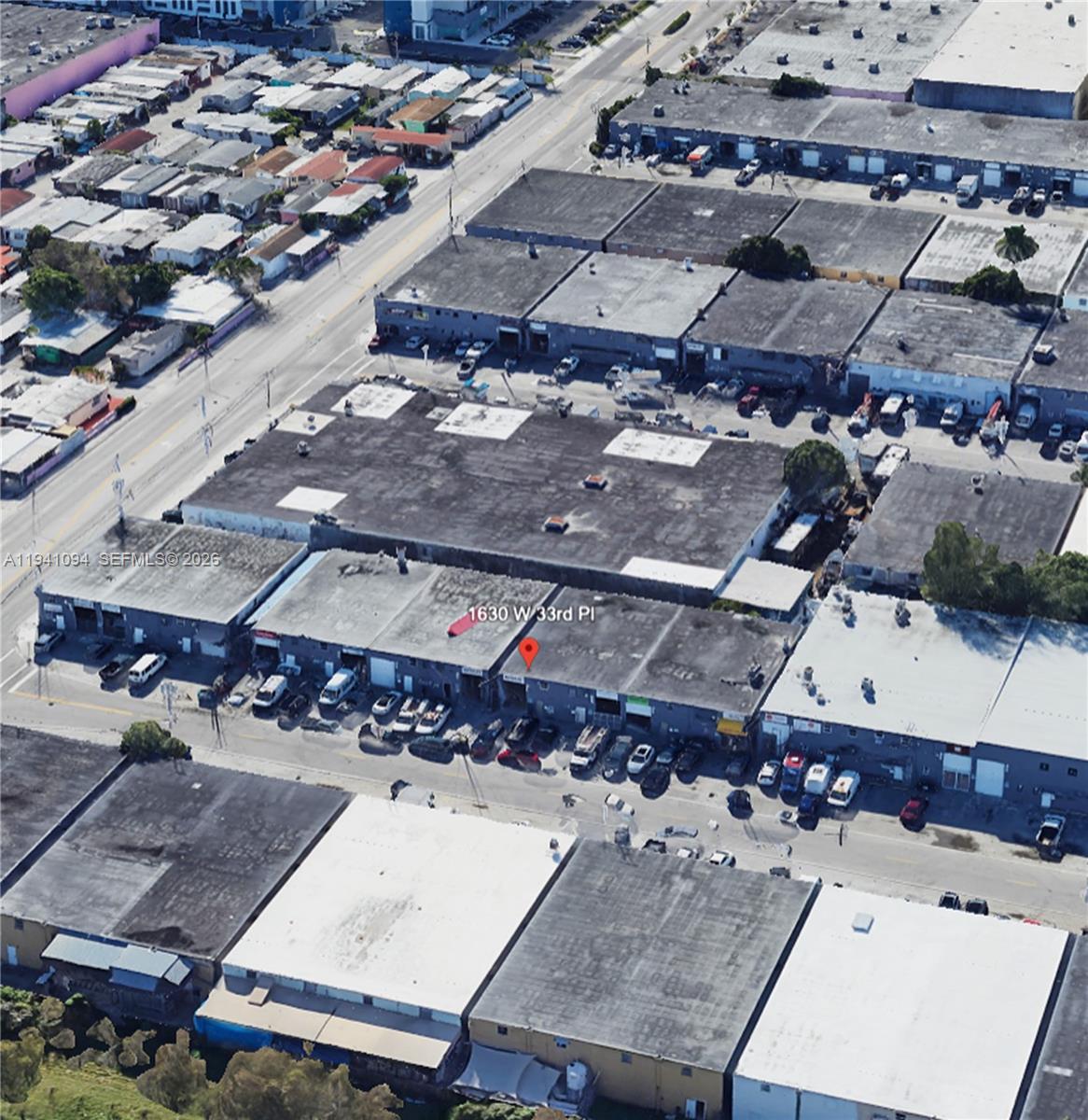 An aerial view shows a row of industrial warehouse buildings with flat roofs and parking — 1630 W 33rd Pl, Hialeah FL 33012, HIALEAH, FL