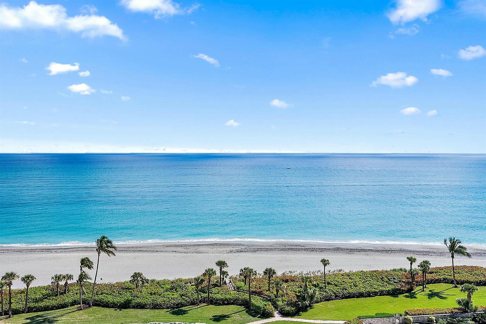 An elevated view of a sandy beach, ocean, and landscaped lawn with palm trees — 400 Ocean Trail Way # 1310, Jupiter FL 33477, JUPITER, FL