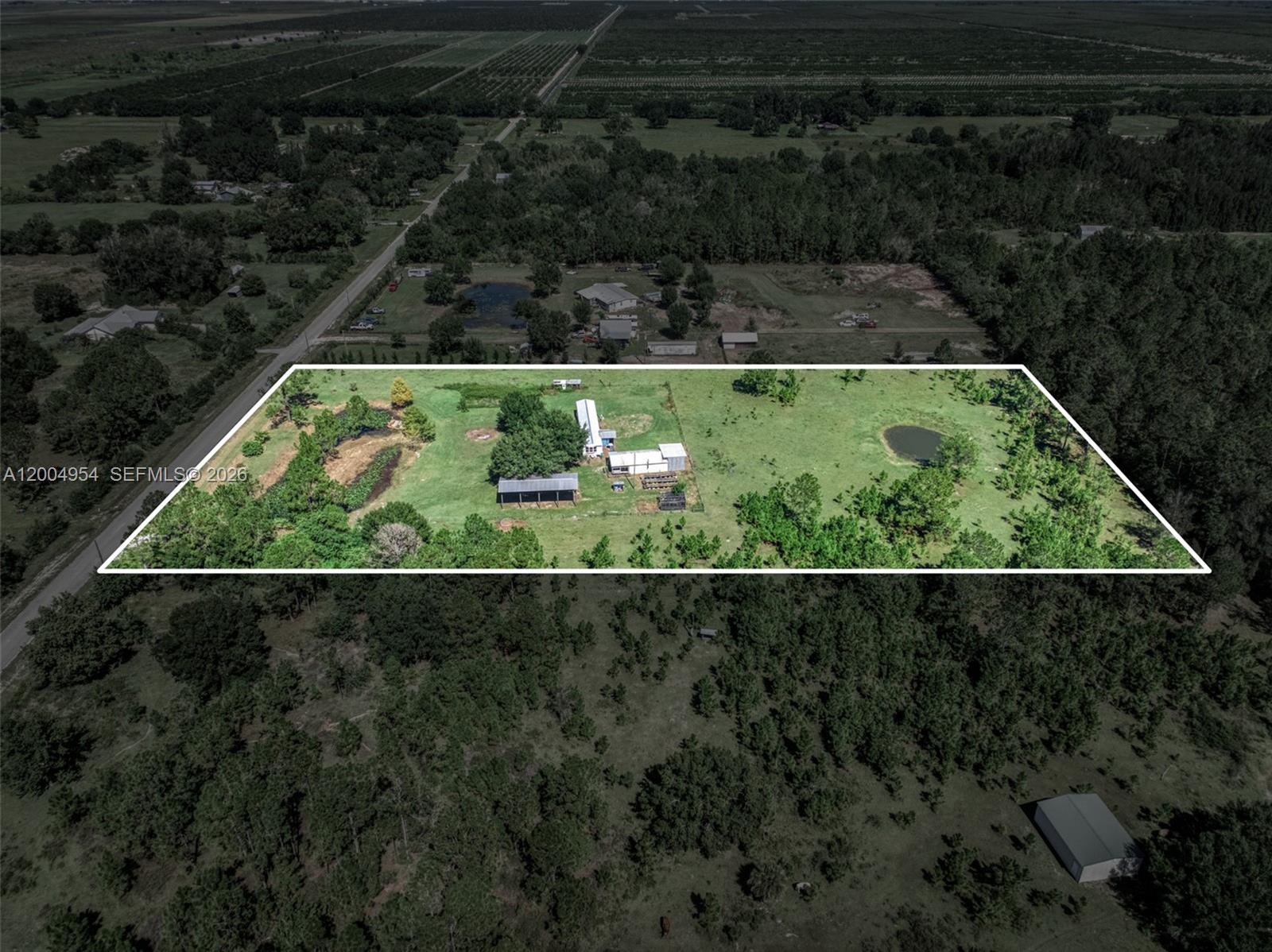 An aerial view shows a rural property with a house, outbuildings, and two small ponds — 2316 Gem Stone, Sebring FL 33857, SEBRING, FL
