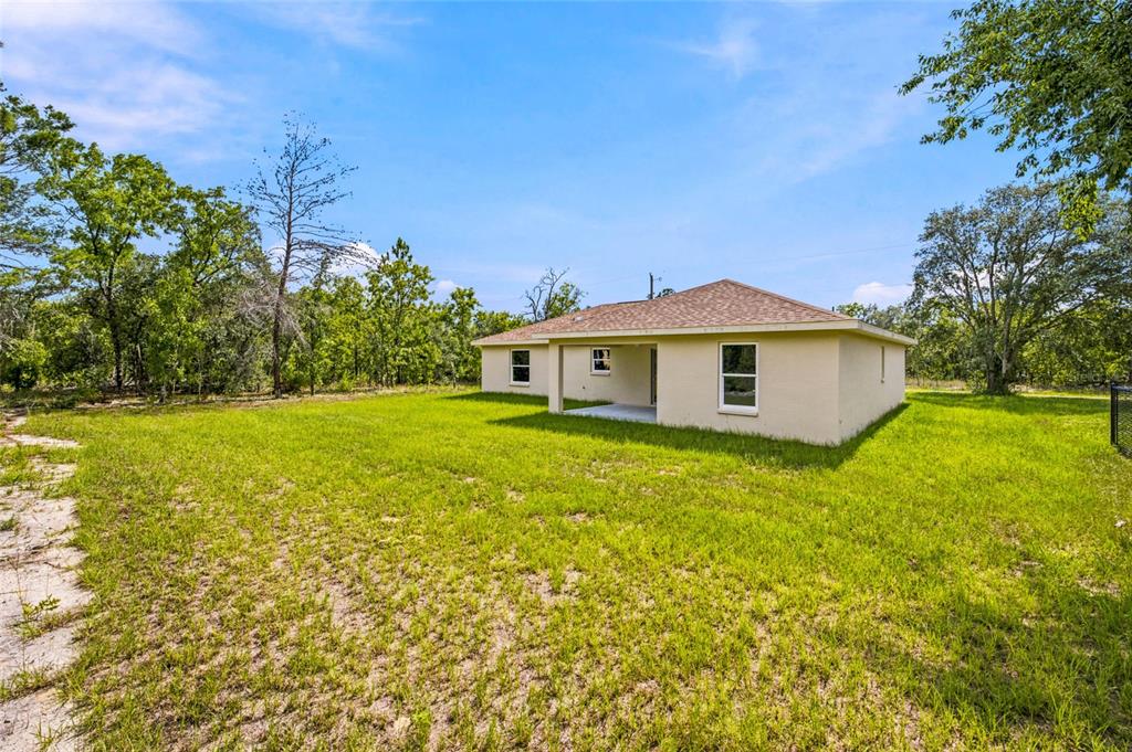 A tan, single-story house with a shingled roof sits on a large, grassy lot — 6243 N MATHESON DRIVE, CITRUS SPRINGS, FL