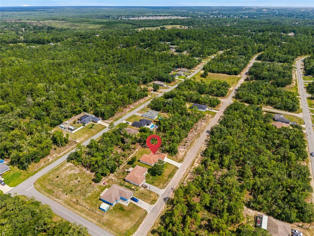 An aerial view shows a single-family home with a red pin in a wooded neighborhood — 6243 N MATHESON DRIVE, CITRUS SPRINGS, FL