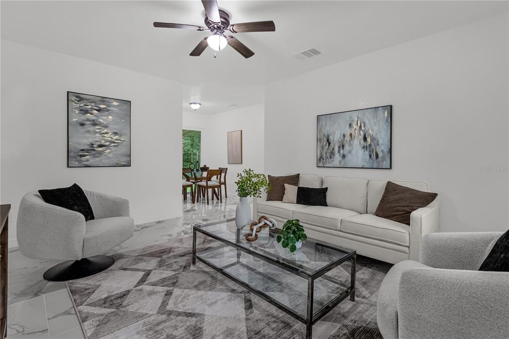 A living room features a white sofa, two armchairs, a glass coffee table, and artwork — 107 FORD AVENUE, ALTAMONTE SPRINGS, FL