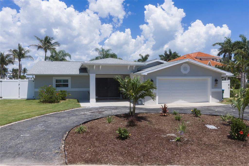 A wide entryway with wood-look flooring leads to an open living area with water views — 303 N BATH CLUB BOULEVARD N, NORTH REDINGTON BEACH, FL