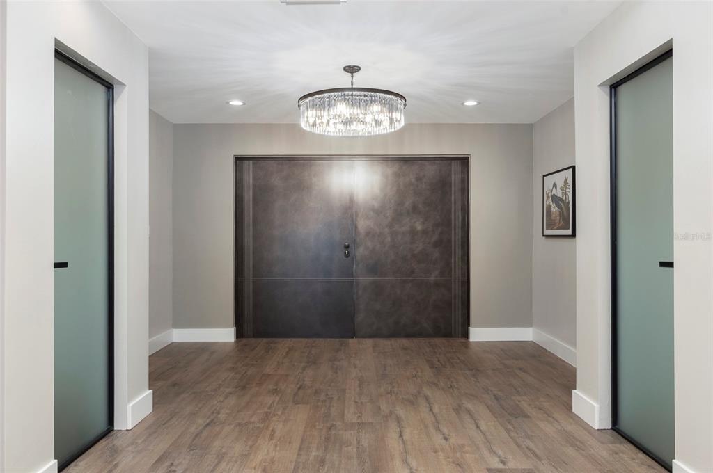 A modern kitchen features a large dark wood island, light gray cabinetry, and stainless appliances — 303 N BATH CLUB BOULEVARD N, NORTH REDINGTON BEACH, FL