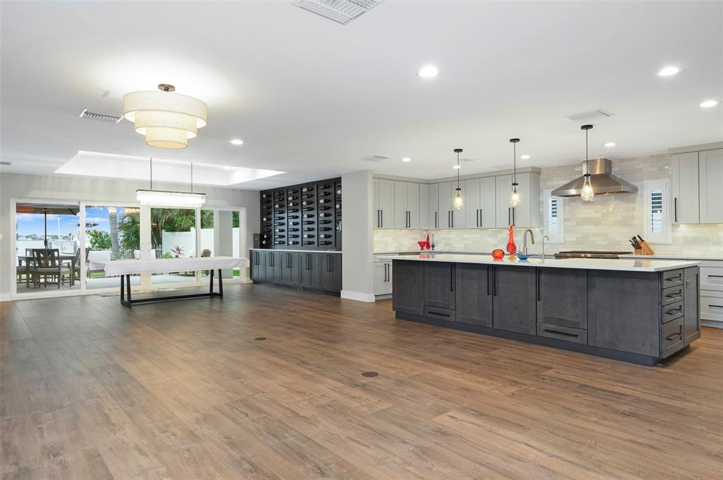 A modern kitchen featuring light gray cabinetry, stainless steel appliances, and a large white island — 303 N BATH CLUB BOULEVARD N, NORTH REDINGTON BEACH, FL