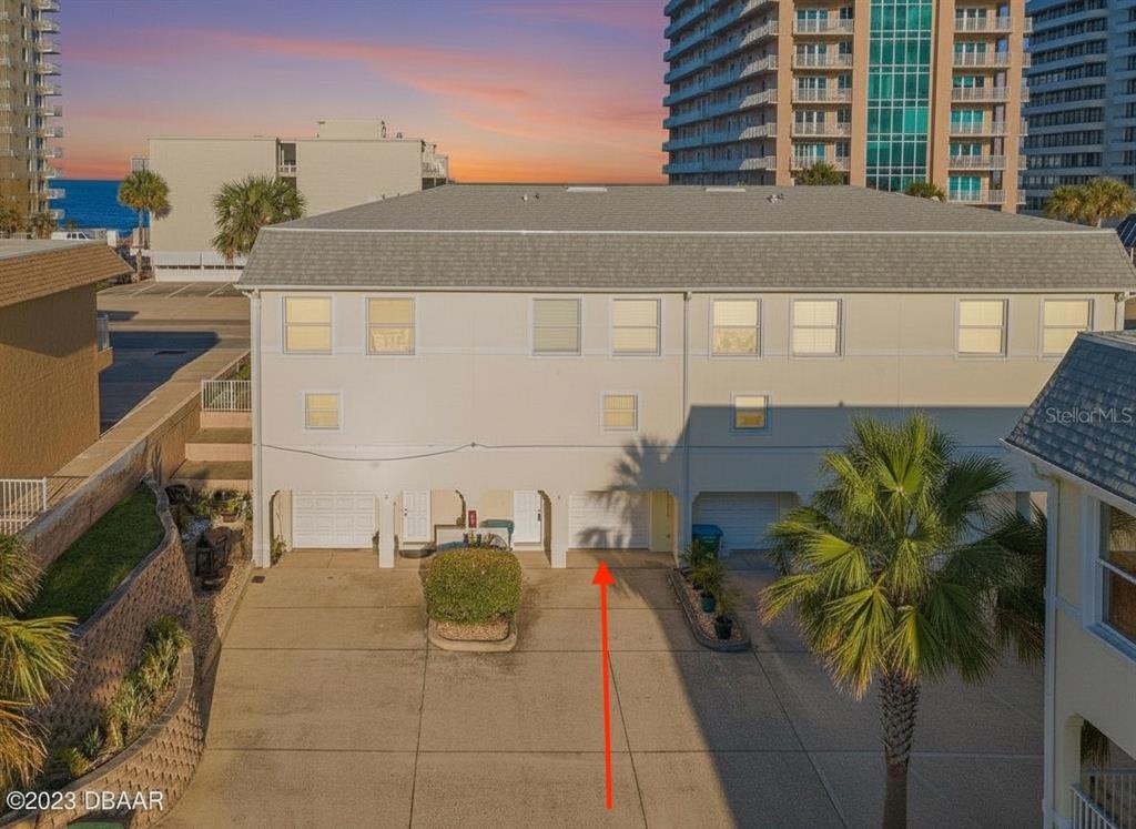 An exterior view of a multi-story townhouse with a concrete driveway and palm tree — 3733 CARDINAL BOULEVARD UNIT 2, DAYTONA BEACH, FL