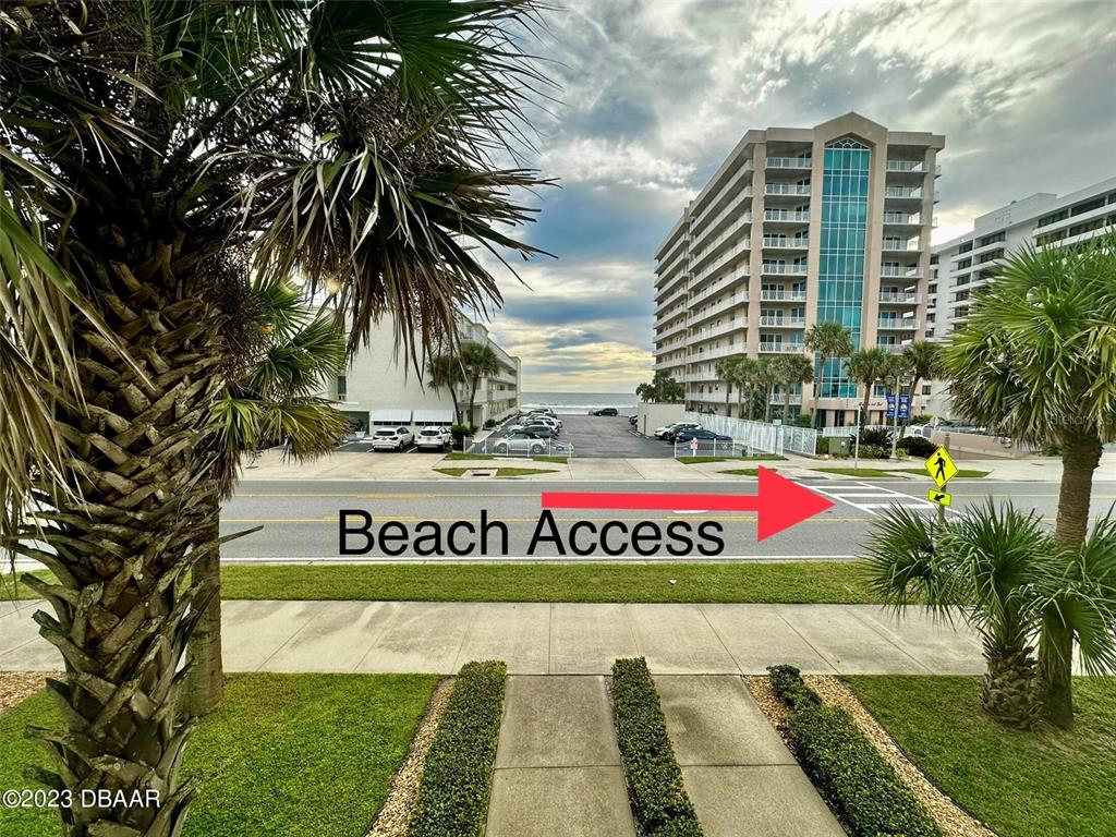 An outdoor view shows a street with a pedestrian crosswalk leading toward a beach — 3733 CARDINAL BOULEVARD UNIT 2, DAYTONA BEACH, FL