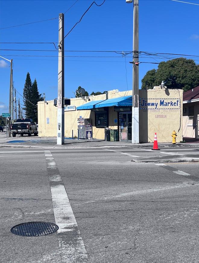 A single-story commercial building with a blue awning and a parking lot in front — 1540 SW 22nd Ave, Miami FL 33145, MIAMI, FL