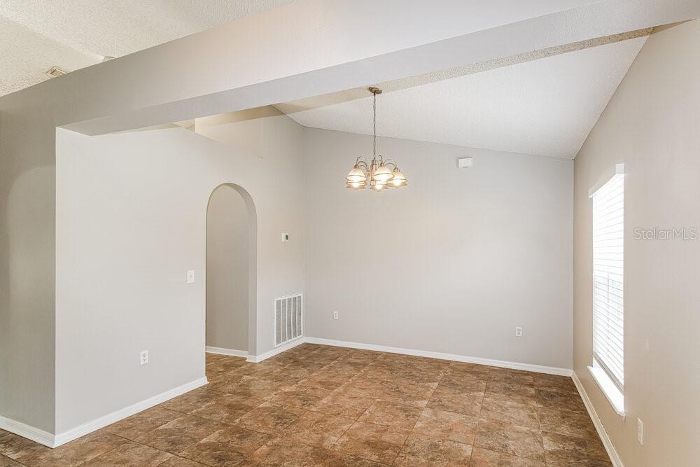 A dining room with vaulted ceilings, tile flooring, and a hanging light fixture — 1159 NEWCOMB AVENUE, SPRING HILL, FL