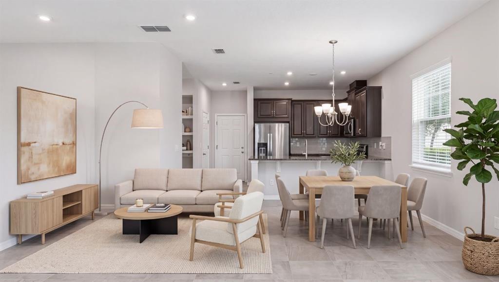 An open-concept living and dining area features a neutral sofa, wooden furniture, and dark cabinetry — 9457 RANDAL PARK BOULEVARD, ORLANDO, FL