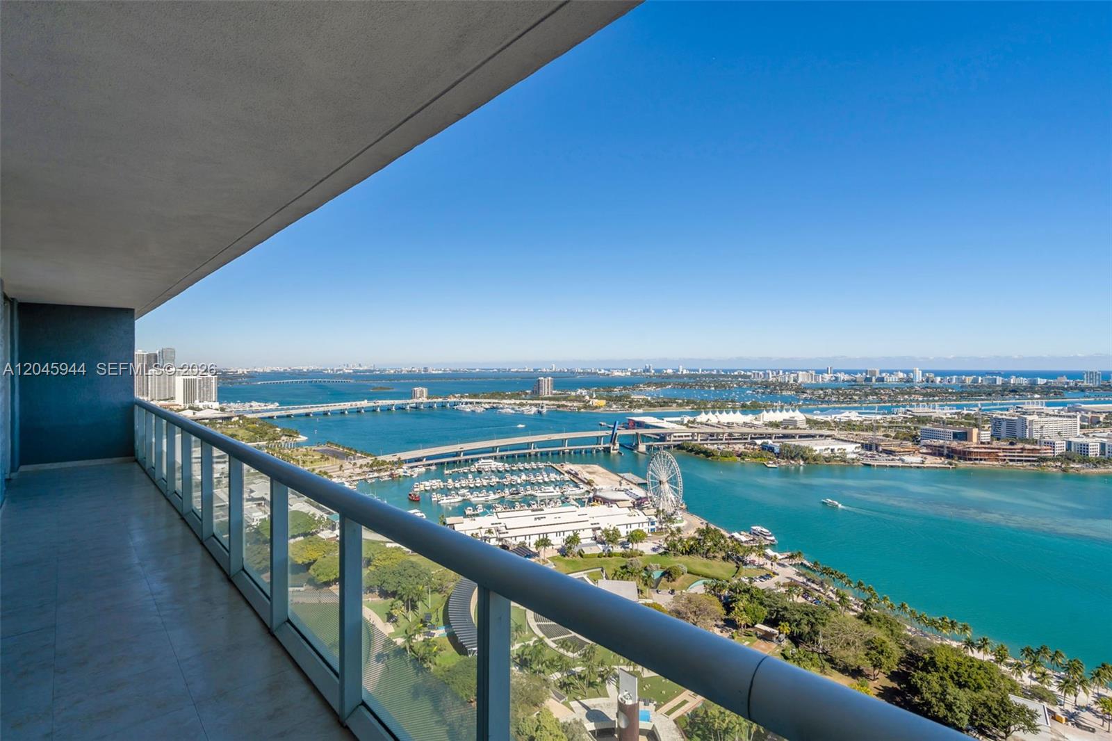 A high-rise balcony overlooks a bay, a marina, a Ferris wheel, and a bridge — 50 Biscayne Blvd # 4208, Miami FL 33132, MIAMI, FL